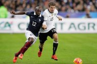 Thomas Mueller of Germany (roentgen) is challenged by France's Lassana Diarra (L) at Stade de France.